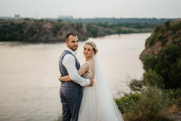 bride blonde girl and groom near the river