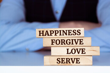 Inspirational single kind word on wooden blocks about happiness, forgive, love and serve.