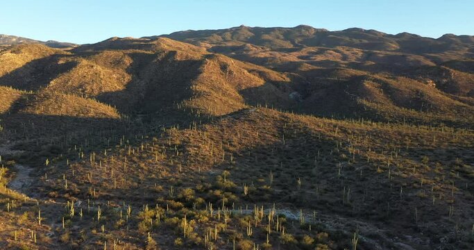 The low angled sun casts long shadows upon the desert hills and mountains near Saguaro National Park, Arizona.