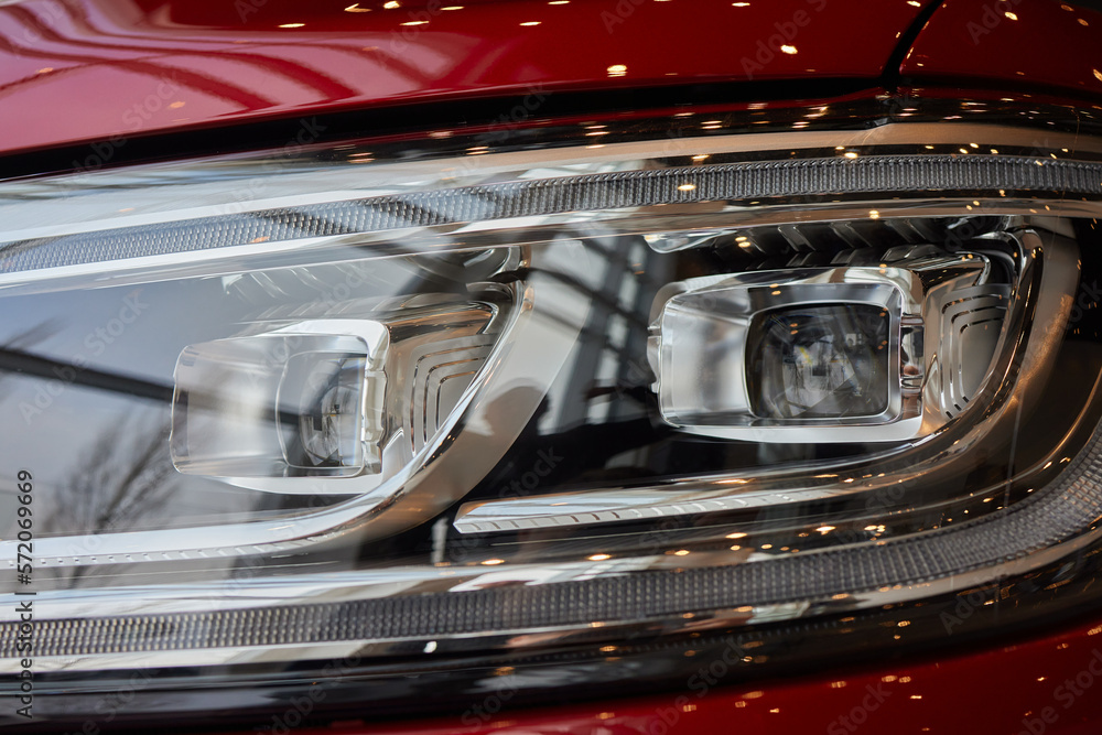 Poster Headlights and hood of sport white car with silver stars.