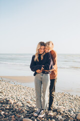 couple hugging on the beach and smiling down