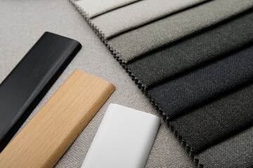 Black, white and natural wood color on fabric swatches background. Selection of materials for the interior.
