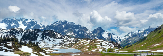 Summer mountain panorama to small Kalbelesee lake and snow thawing meadow (Warth, Vorarlberg, Austria).
