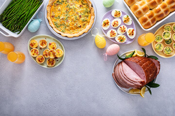 Easter brunch table with ham, quiche, hot cross buns