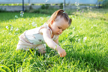 Baby toddler playing with bubbles outdoors. Having fun. Concept of childhood, family and love