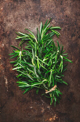 Fresh rosemary bunch on old brown rusty metal background. Spices for cooking  Top view