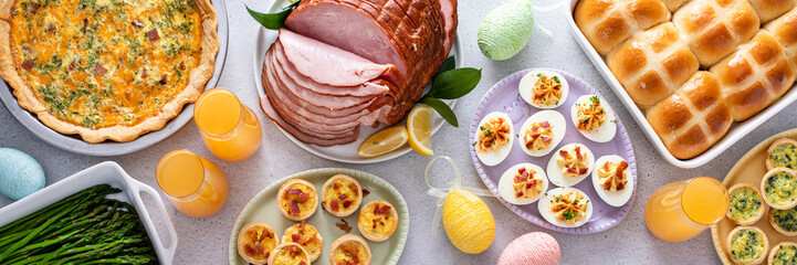 Easter brunch table with ham, quiche, hot cross buns