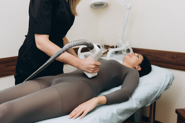 Beautician doing a beautiful figure for a woman, using the LPG apparatus
