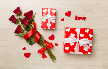 Valentines day gift box with red roses on wooden background, top view