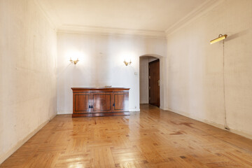 Empty room with quality parquet wooden floor and a wooden dresser with inlaid decorations