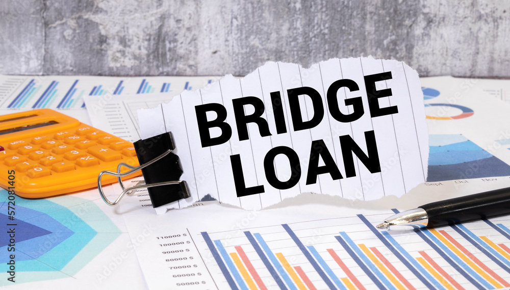 Poster business concept. top view of notepad with text bridge loan on the wooden background.