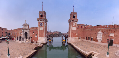 Venice. Old stone towers of the arsenal over the canal on a sunny day.