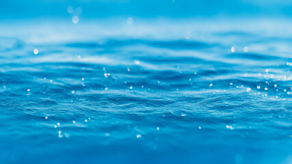 Bright water surface with blue bokeh and glitter effects.