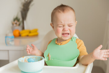 the kid does not want to eat food on the table,a child of 1 year is naughty at the table. The...