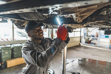 Afro-American serviceman replacing a clutch on a car at work, car repair concept. High quality photo