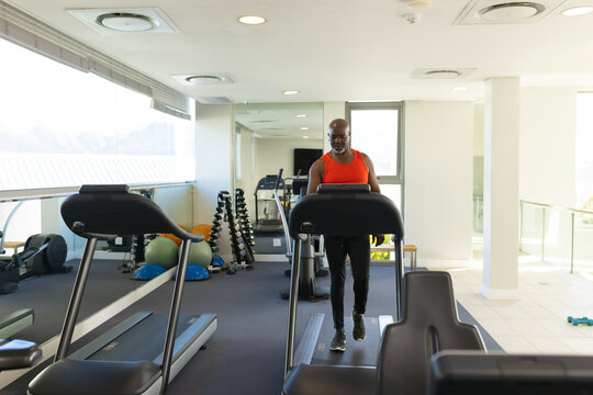 African American Senior Man Walking On A Treadmill At The Gym