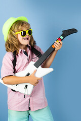 Musik education. Happy smiling child learning to play the guitar. Rock and roll guitar.