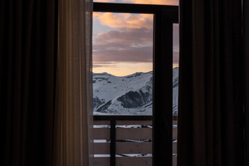 beautiful view from hotel room window at winter mountain at ski resort, sunset