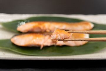 北海道産の焼き鮭を箸で持ち上げている