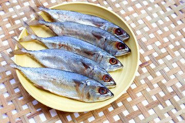 Salted fish in yellow plat on bamboo weave plate
