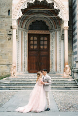Bride and groom stand in front of the Basilica of Santa Maria Maggiore. Bergamo, Italy