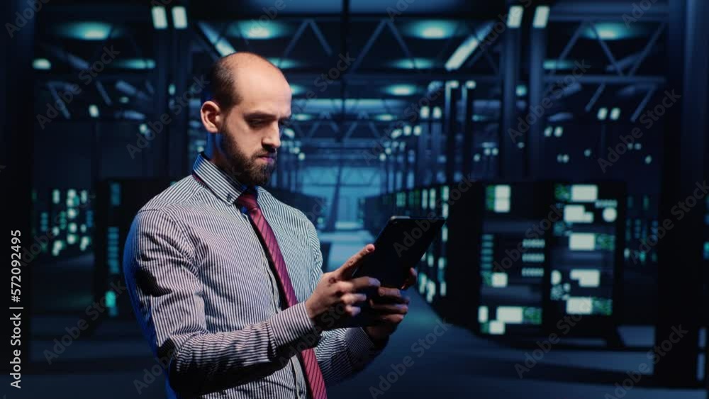 Poster information security officer working in data center with tablet, analyzing server rack cabinets in r