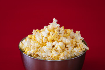 Cinema concept: Metal container  with fresh delicious butter popcorn. Movie night at home.