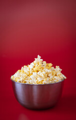 Cinema concept: Metal container  with fresh delicious butter popcorn. Movie night at home.