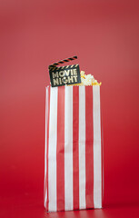 Cinema concept: paper bag with fresh delicious butter popcorn. Sign: "Movie night".