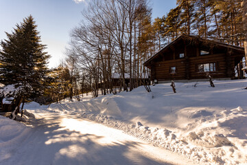 The woods log cabins with snowy rooftop, deep snow outside, morning serene natural landscape in Japan on January 2023.