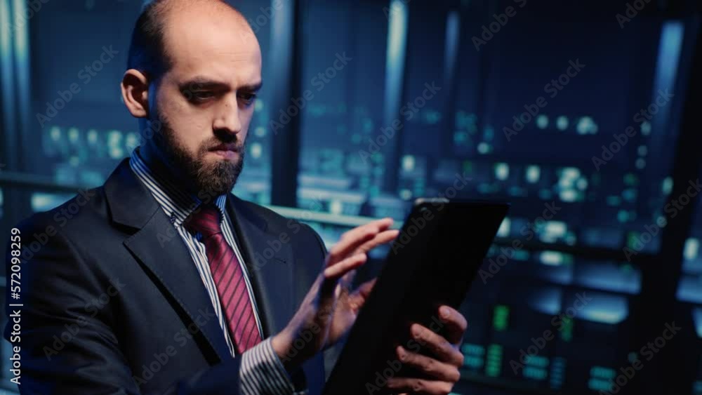 Poster male database admin checking hosting server on tablet in data center, analyzing mainframe computer p