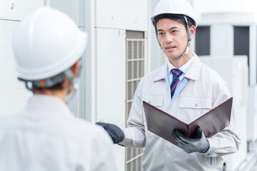 ビルの屋上で打ち合わせをする作業員