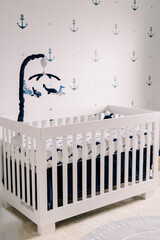 A cute white crib in a baby's nursery room with a natural theme. 