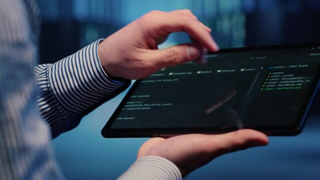 Male database technician looking at hosting server on tablet, working on cyberspace networking. Infrastructure specialist inspecting mainframe computer processor for backup. Handheld shot. Close up.