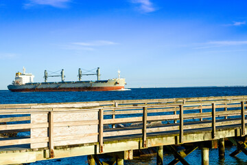 Fishing pier and passing tanker