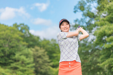 ゴルフ場でゴルフをするゴルファーの女性(笑顔・ティーショット・ゴルフコンペ)　撮影協力：あづみ野カントリークラブ