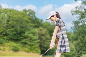 Naklejka na ściany i meble ゴルフ場でゴルフをするゴルファーの女性(笑顔・ティーショット・ゴルフコンペ)　撮影協力：あづみ野カントリークラブ