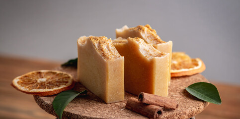 Pieces of natural orange soap on the wooden background. Concept of making and using organic eco soap and cosmetics