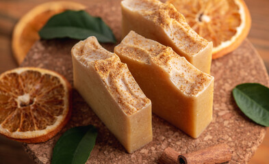 Pieces of natural aromatic soap and slices of orange, cinnamon and green leaves on the table