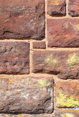 Old sandstone blocks used to create irregular sized brick wall. 