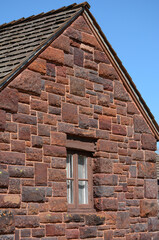 House constructed of Irregular sandstone brick and wood shingle roof. 