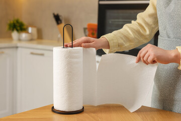 Woman using paper towels in kitchen, closeup