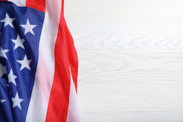 American flag on white wooden table, top view. Space for text