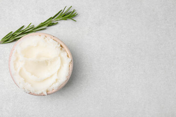 Delicious pork lard in bowl and rosemary on light table, flat lay. Space for text