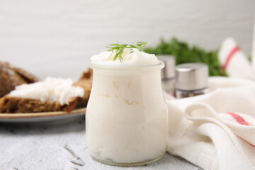 Delicious pork lard with dill in glass jar on light textured table, closeup