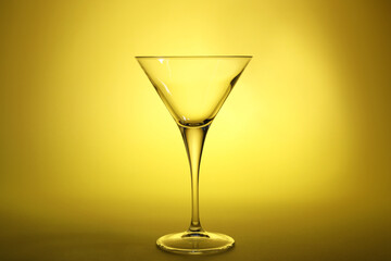 Elegant empty martini glass on yellow background