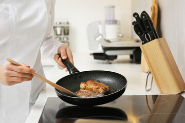 Chef cooking delicious meat with thyme in frying pan indoors, closeup