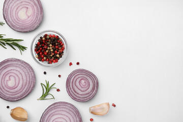 Obraz na płótnie Canvas Fresh red onions, garlic, rosemary and spices on white background, flat lay. Space for text