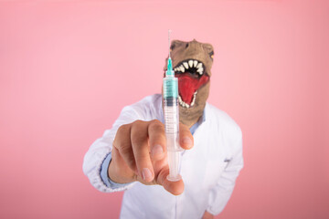 dinosaur doctor holding a syringe close-up, selective focus on an isolated pink background