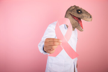 doctor with a dinosaur head holding the symbol of fighting cancer on an isolated pink background